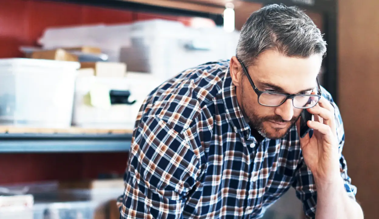 53ba - man with glasses and beard on phone - 1248x720